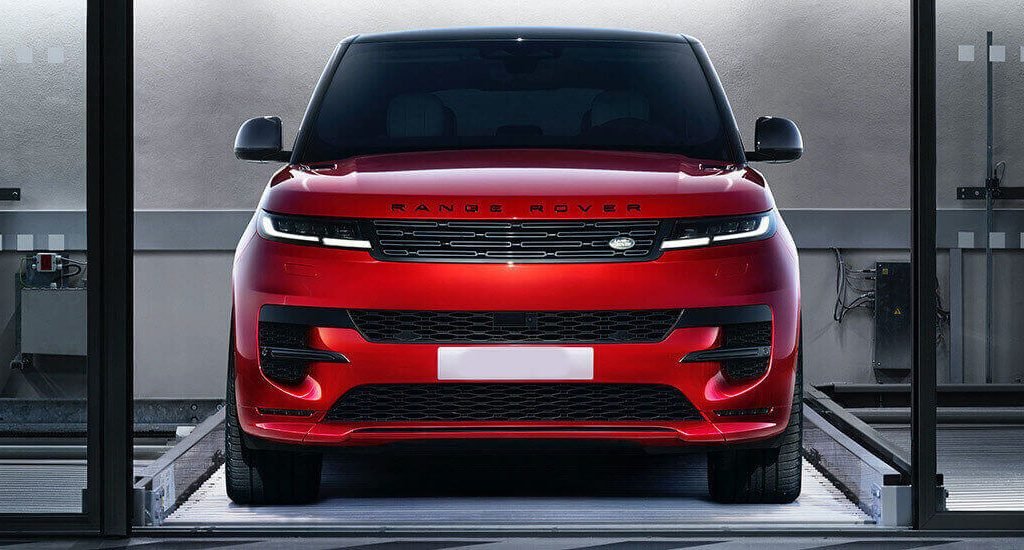 Red Range Rover viewed from the front inside a wash bay