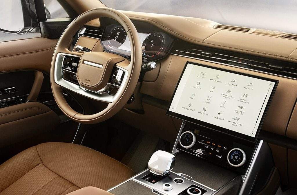 Range Rover cabin with tan trim, steering wheel, touchscreen and center console